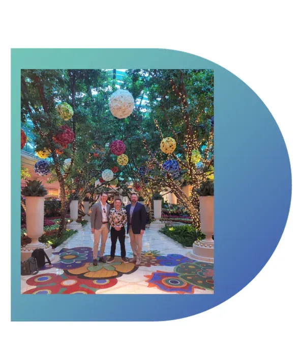 chart Three Lavanda team members standing beneath a colourful garden display in Las Vegas.