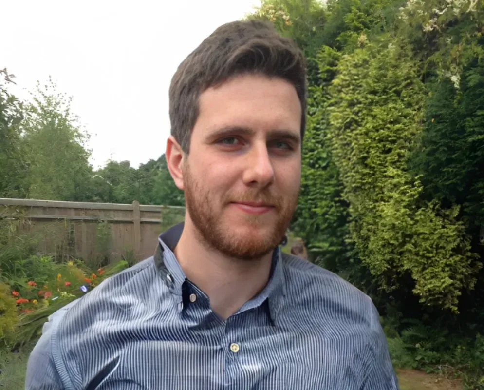 A portrait of Leigham, Head of QA, in a garden.